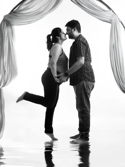 A playful and romantic black and white silhouette. The 'almost kiss' pose and the water reflection effect create a fun and artistic image of the couple's connection.