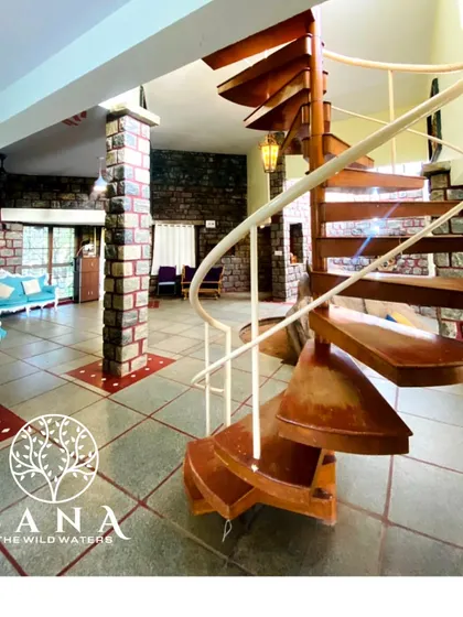 The villa's interior combines rustic stone walls with elegant design, including this striking wooden spiral staircase, creating a unique and upscale environment for your team.