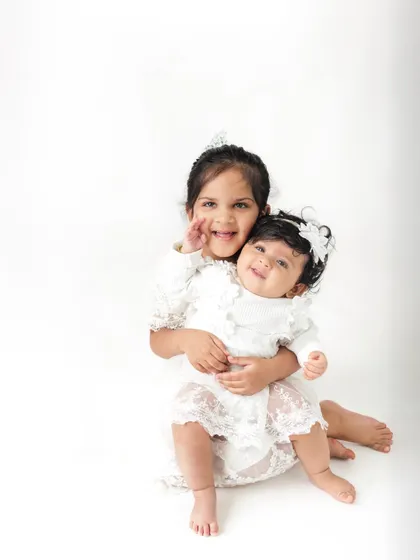 The sweetest hug between sisters celebrating a half birthday. Including siblings in milestone shoots always adds an extra layer of love and fun.