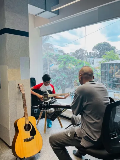 A behind-the-scenes look at a guitar lesson in progress. Our modern, light-filled studios provide an inspiring space for learning.