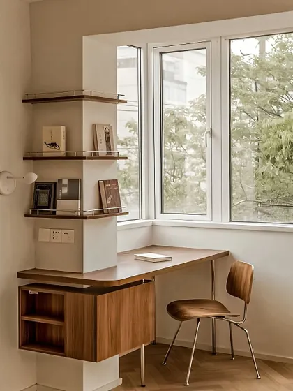 A minimalist study corner that makes great use of vertical space. The curved desk fits neatly into the corner by the window, and the unique shelving provides storage without feeling bulky.