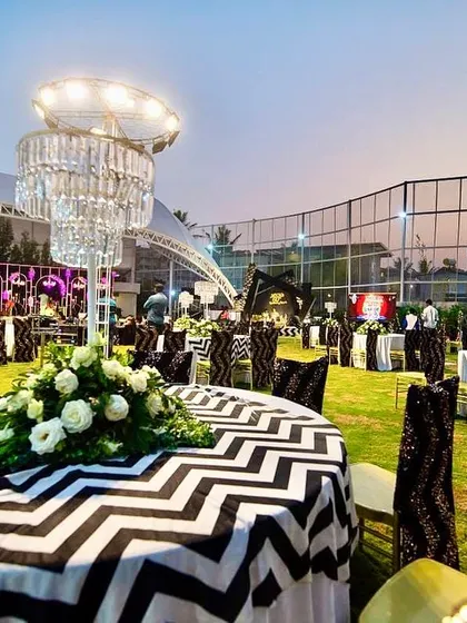 For the 60th birthday, we extended the black and white chevron theme to the outdoor seating and entrance arch. Themed furniture and chandelier centerpieces created a cohesive and elegant experience.
