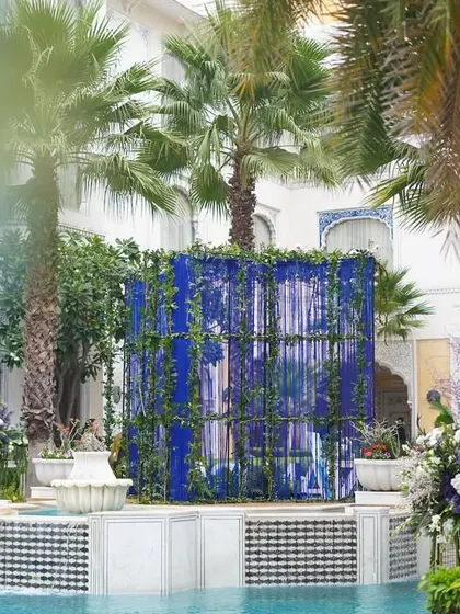 A view across the pool, showing a large blue backdrop made of hanging tassels. This created a beautiful screen of color against the palace architecture.