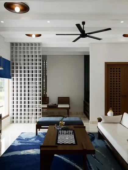 This angle highlights the functional layout of the living room, featuring a wall-mounted TV and a stylish console. The blue patterned rug adds a splash of color, anchoring the seating area and complementing the wooden furniture.
