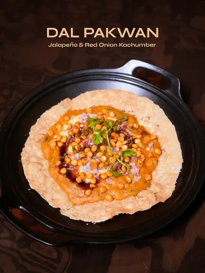 Dal Pakwan, a Sindhi classic, reimagined. The combination of the crispy base, savoury dal, and fresh toppings makes for a textural and flavourful snack.