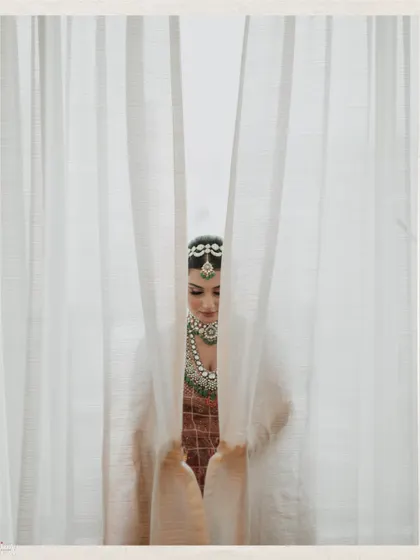 A mysterious and beautiful shot of the bride looking down, partially hidden by curtains.