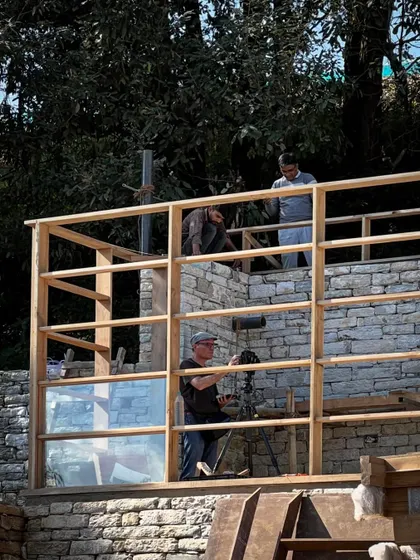 Photographer Ariel Huber sets up a shot within the timber frame of a guesthouse. Documenting the process is key to sharing the story of how these complex buildings come together in such a stunning environment.