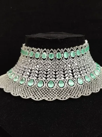 A wide, intricate choker made with American diamonds and pastel green stones. This is a statement rental piece for a bride who wants a contemporary look.