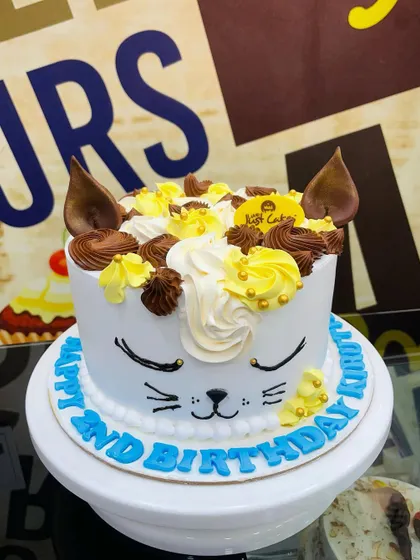 A sweet 1.5kg cat-themed cake with piped whiskers and chocolate ears.