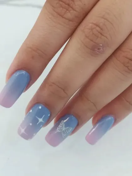 A close-up of the hand-painted stars and butterfly on the pastel ombré background.