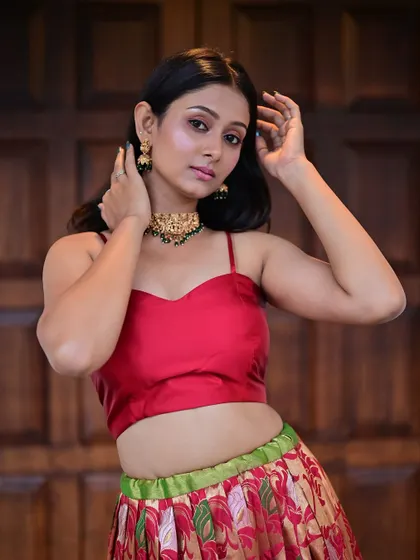 A model in a red crop top and printed skirt.