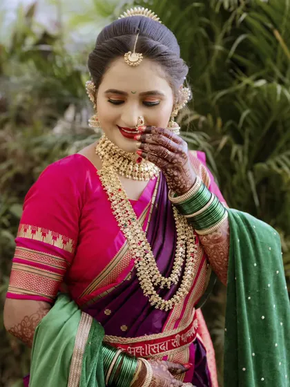A candid moment of a bride adjusting her nath. These small, unposed actions are what make wedding albums feel real and personal.