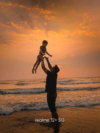 A heartfelt silhouette of a father and child against a golden sunset at the beach. This image is all about emotion and capturing a fleeting, joyful moment.