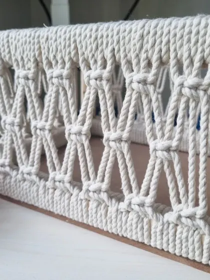 A side view of the basket, highlighting the clean lines of the wooden frame and the consistent, beautiful knot work.