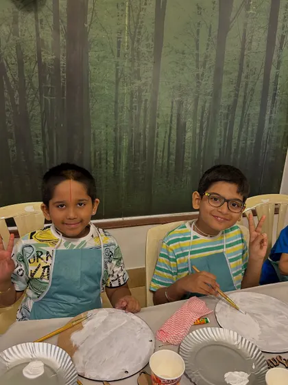 Peace, smiles, and painting. These boys are clearly having a great time at the art table, showing that creativity and fun go hand in hand.