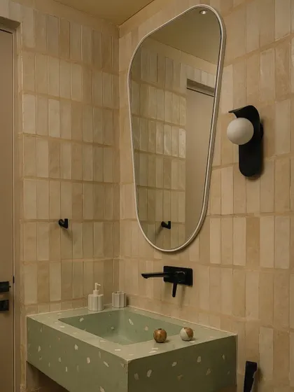 A powder room featuring a terrazzo sink and handmade tiles. This space shows how we use color and material to give each bathroom a unique essence.