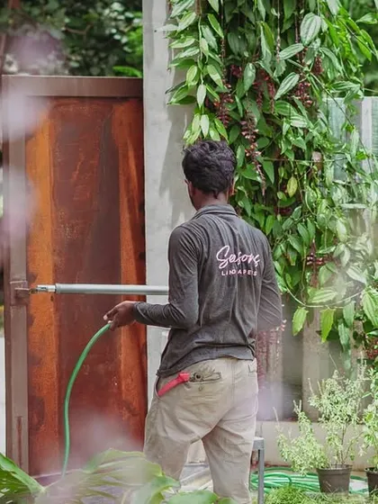 It's the quiet, consistent care that keeps a space alive. A team member watering the garden is a daily ritual that ensures every plant gets the hydration it needs, preserving the calm and beauty of the landscape.