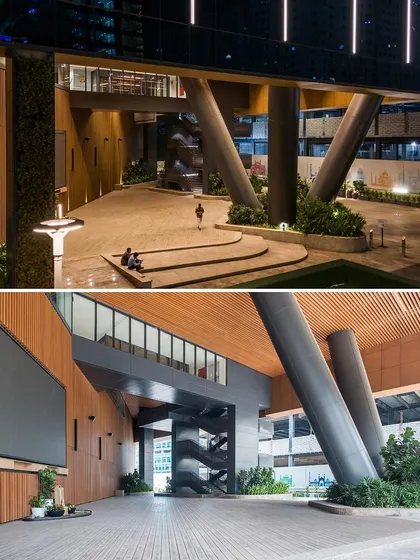 The triple-height plaza at V Park at night, illuminated to create a welcoming public space. The design includes stepped seating and dramatic structural columns, making it a landmark for the city's IT community.