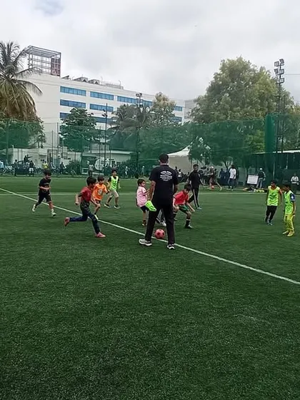 Our coach guiding a group of young players during a football drill. We focus on fun, fundamentals, and active participation.