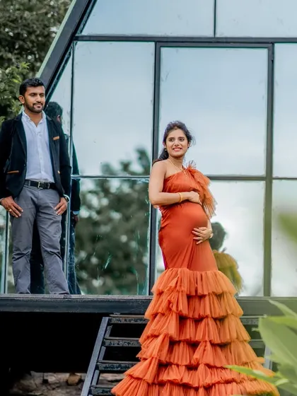 The Bronze gown against a modern, A-frame house. The dress's vibrant color and dramatic silhouette make it a standout choice for any location.