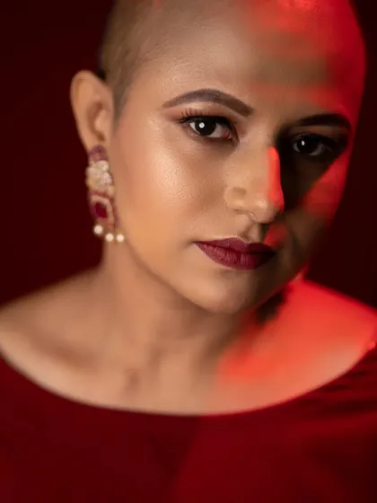 A striking close-up using dramatic lighting. The makeup, especially the defined eyes and lips, holds its own, creating a powerful and intense portrait.