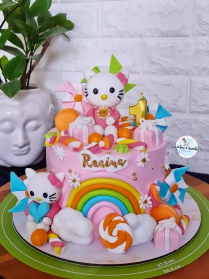 A super colorful and fun Hello Kitty themed cake for a first month birthday. It's loaded with handmade fondant details like rainbows, gift boxes, and of course, Hello Kitty herself.