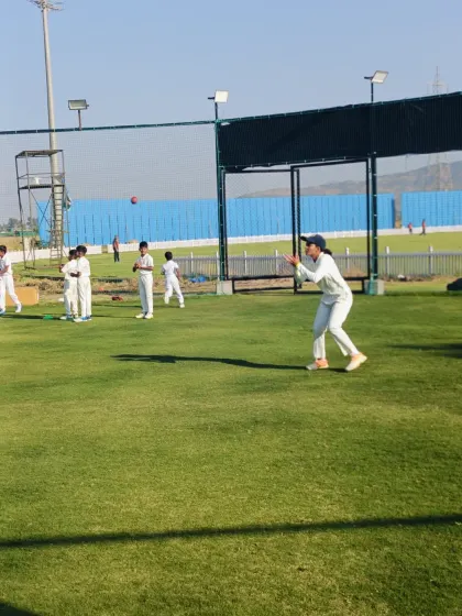 A female cricketer confidently gets into position to take a catch, showcasing her focus during our integrated fielding drills for all our players.