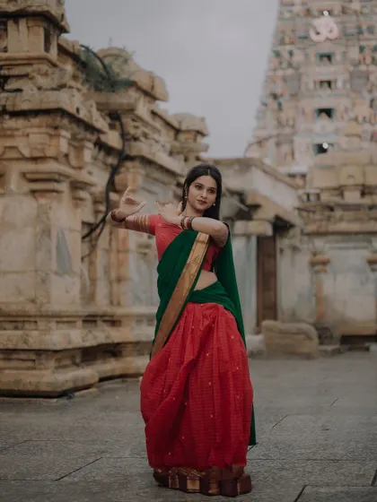 A full-body shot of a dancer in traditional attire against a temple backdrop. This image captures the grandeur of both the costume and the location.