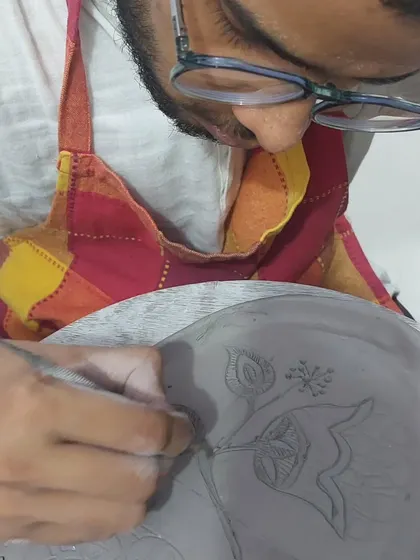 The level of detail and creativity that comes from first-time students always amazes me. This student is carefully etching a beautiful floral design onto his hand-built plate. It's a process that requires patience, and he did a wonderful job.