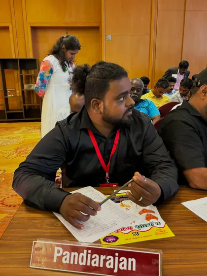 A candid photo from a magic convention. My nameplate reads "Pandiarajan," my full name, representing me as a professional in the field.