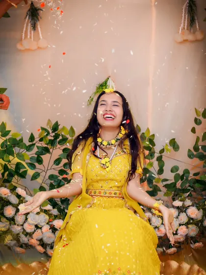 The sheer delight of a Haldi ceremony, with flower petals showering a laughing bride. We love capturing the fun and vibrant energy of pre-wedding festivities.