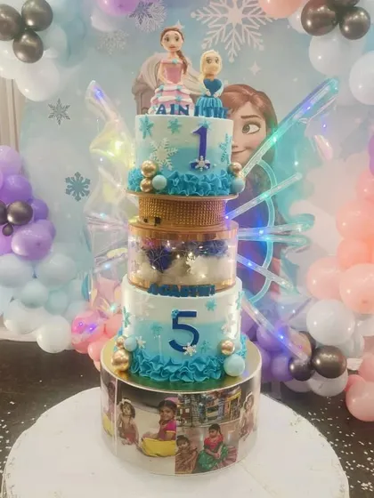 Another view of the five-tiered Frozen cake, highlighting the photo-customized bottom tier and the impressive height of the creation.