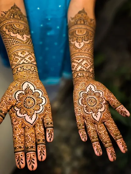 A beautiful mandala design on the palm, using negative space to make the central flower pop.