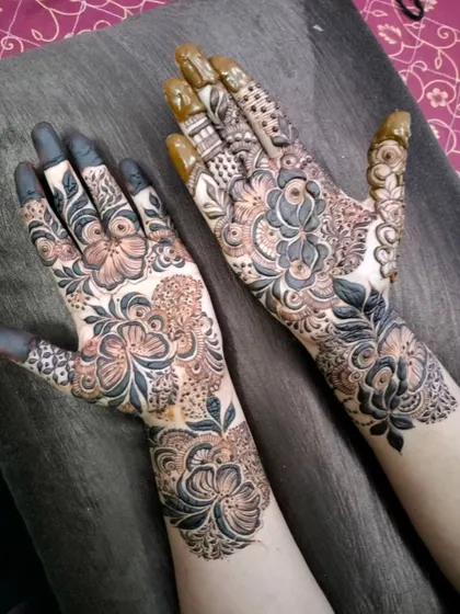 Two hands, two complementary designs for a bride and her siders. One hand features bold, shaded florals while the other has more delicate, spaced-out motifs, showing how I can create a unified look for the whole bridal party.