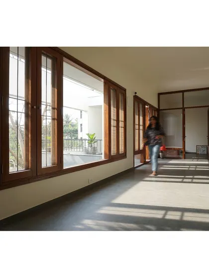 The repetition of windows and shadows creates a strong rhythm along the corridor.