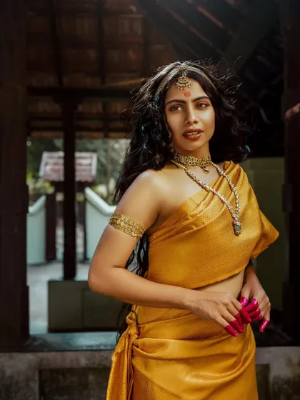 A full-length portrait from 'Thamara' that highlights the elegant, flowing drape of the saree.