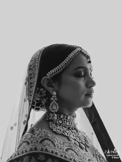 A serene and classic black and white side profile of the bride, Krutika, capturing her elegant features and intricate jewelry.