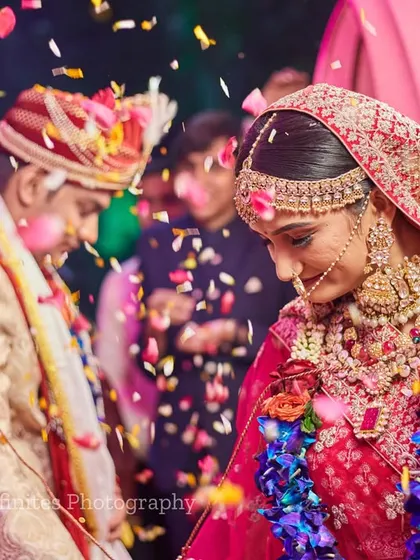 The moment of celebration, captured with falling confetti. The motion and vibrant colors make this a dynamic and exciting wedding photo.