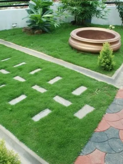 A closer look at a lawn with inset stepping stones and a paved walkway. This combination of hardscaping and softscaping creates a balanced and functional garden design.