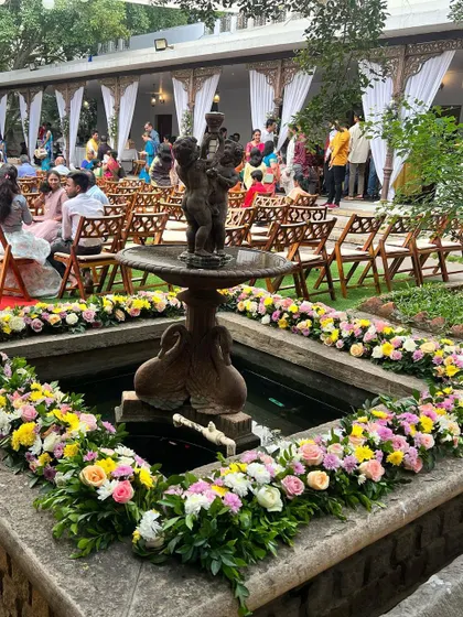A beautiful floral arrangement surrounding a fountain, adding a touch of elegance and nature to the venue.