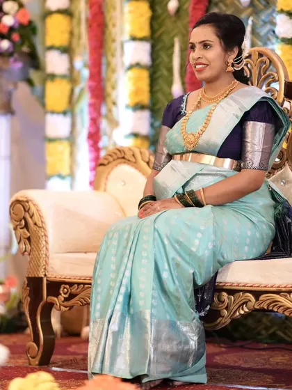 Seated gracefully during her baby shower ceremony. The makeup is subtle yet defining, ensuring she looks her best for this important tradition.