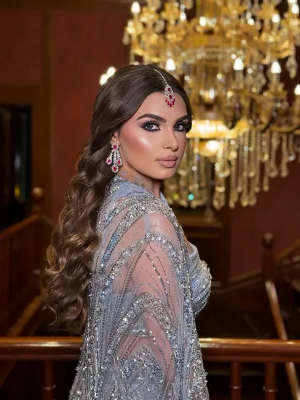 A dramatic shot showcasing the entire look. The chandelier in the background adds to the opulent and glamorous feel of her cocktail night.