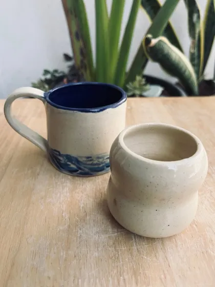 A wave-patterned mug and a curvy checkered pot, both made by students in our wheel-throwing classes.