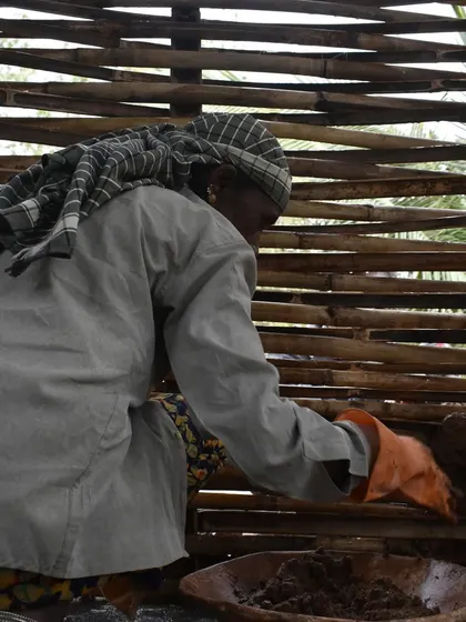 A mason applies mud plaster to a woven bamboo wall. This is a core skill in our wattle and daub training, combining natural materials to create durable structures.