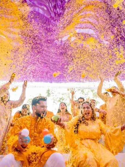 A spectacular 'phoolon ki holi' where guests shower the couple with a vibrant explosion of yellow and purple flower petals.