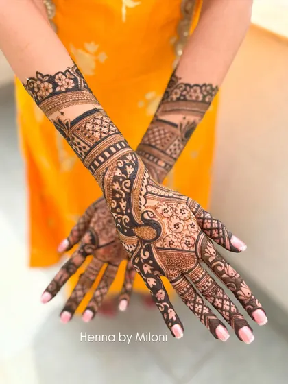 A gorgeous full hand design featuring bold peacock motifs. The dark, rich stain highlights the intricacy of the patterns.