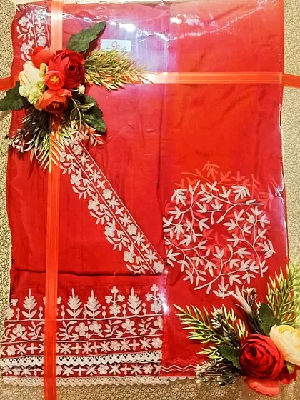 A beautiful red suit with white embroidery, packed simply to let the outfit shine.