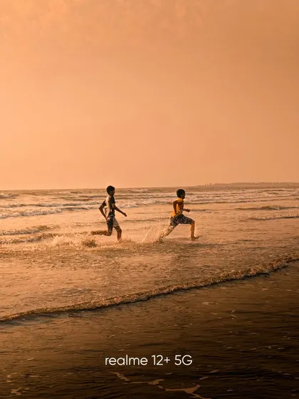 Two boys running along the shoreline at sunset. This shot captures the energy and freedom of childhood, with the warm, golden light creating a nostalgic feel.