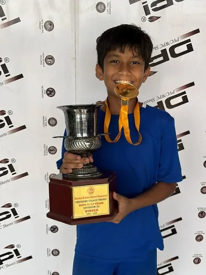 Khush Modi proudly holding his championship trophy and medal, a result of his dedication.