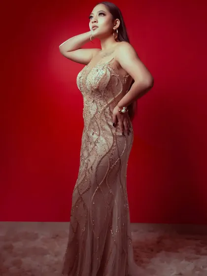 A full-length shot showcasing the elegant silhouette and detailed embellishments of this beautiful champagne gold gown.